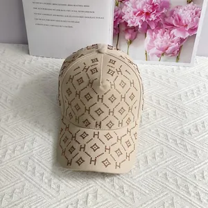 Détail de la casquette beige avec motif H en strass et matelassage géométrique