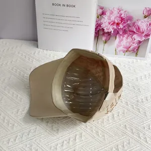 Vue détaillée de la casquette beige avec monogramme de luxe et lettrage en strass