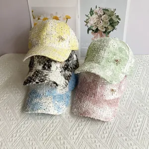 Detail showing various colors of sequin baseball caps with a small diamond bow