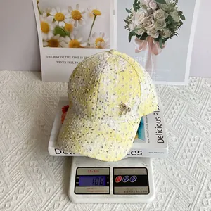 Detail showing a 106g sequined baseball cap with a bow accessory on an electronic scale