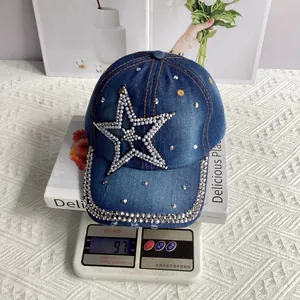 Close-up of denim baseball cap with pearl star detail on scale weighing 97 grams