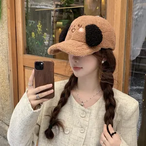 Detail of soft brown lamb wool baseball cap with cute puppy ears and cartoon embroidery