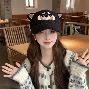 Détail de la casquette en polaire noire avec broderie chiot et oreilles sur modèle