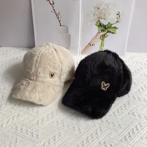 Winter faux rabbit fur baseball caps in black and cream with gold butterfly accent
