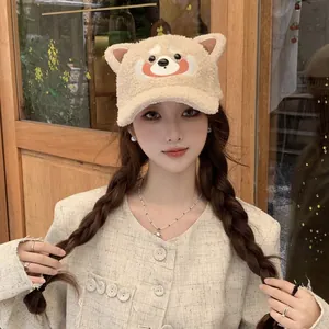 Détail du visage d'animal brodé et des oreilles en peluche sur la casquette beige