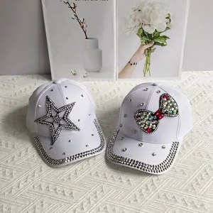 Detail of white denim baseball caps with rhinestone star and bow patterns for women