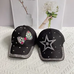 Close-up of black denim baseball caps with rhinestone bows and star decorations