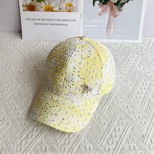 Detail of yellow sequin baseball cap with pearl bow buckle and tweed fabric texture