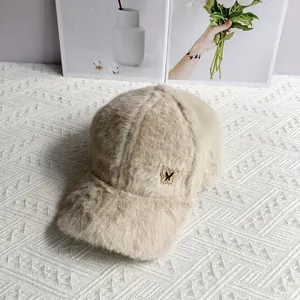 Detail of soft faux fur baseball cap with elegant golden metal butterfly badge decoration