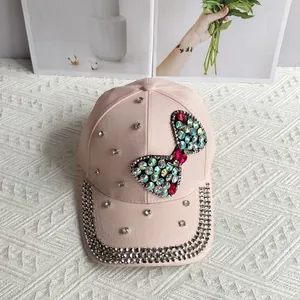 Close-up of pink denim baseball cap with crystal bow and rhinestone-studded brim
