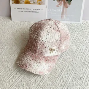 Detail of pink tweed baseball cap featuring silver sequins and pearl bow decoration