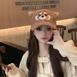 Détail de la casquette en peluche marron avec oreilles d'animaux et broderie koala