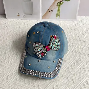Close-up of light blue denim baseball cap with rhinestone bow and silver crystal studs