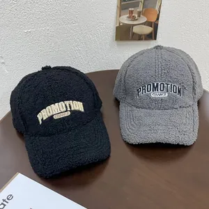 Detail of plush fleece baseball caps in black and grey with PROMOTION embroidery