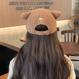 Détail d'oreilles d'ours et broderie animale sur casquette en polaire sherpa brune