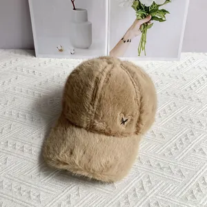 Detail of khaki faux rabbit fur baseball cap featuring a rhinestone butterfly ornament