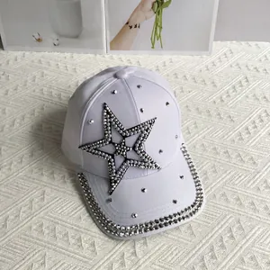 Detail of white denim baseball cap with rhinestone star and pearl bow embellishments