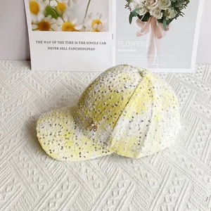Close-up of yellow plaid tweed baseball cap with silver sequins and pearl bow detail