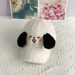 Detail of white sherpa baseball cap featuring embroidered puppy face and black ears