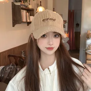Detail view of khaki corduroy baseball cap with embroidered GOOD letters on female model