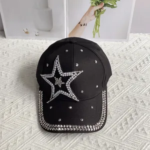 Detail of a black denim baseball cap featuring a pearl and rhinestone star decoration