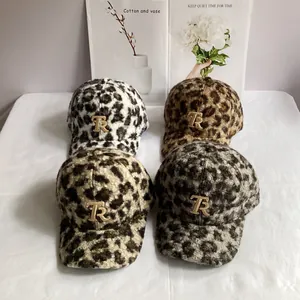 Macro shot of faux fur leopard print baseball caps with golden metal R logo details