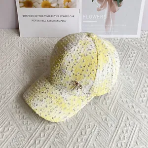 Close-up of yellow plaid baseball cap with sequins and a pearl bow accent