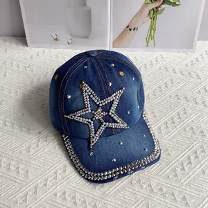 Detail of denim baseball cap with rhinestone star and pearl accents on fabric
