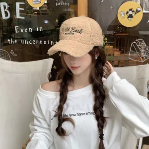 Detail of beige sherpa baseball cap with Wild Back WINTER embroidery on a female model
