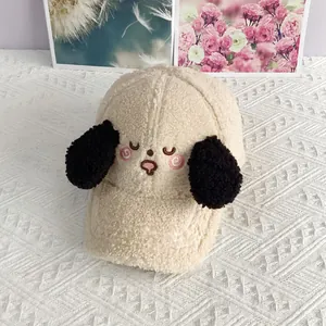 Detail of embroidered cartoon puppy face and fuzzy black ears on cream lamb wool cap