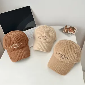 Three plush baseball caps in brown, cream, and khaki with embroidered text design