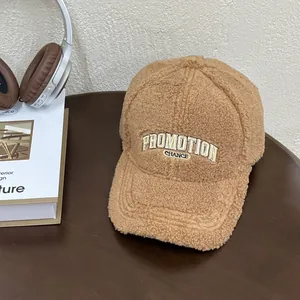 Close-up of brown plush fleece baseball cap featuring detailed PROMOTION embroidery