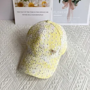Close-up of yellow and white tweed baseball cap with silver sequins and a bow