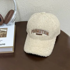 Close-up of cream fuzzy fleece baseball cap featuring brown PROMOTION letter embroidery