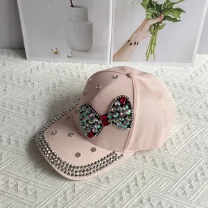 Detail of pink cotton baseball cap with colorful rhinestone bow and sparkling studs