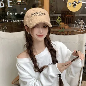 Detail of Mild Back WINTER embroidery on beige fleece baseball cap worn by model