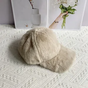 Detail view of plush faux fur baseball cap in beige with premium soft texture for winter