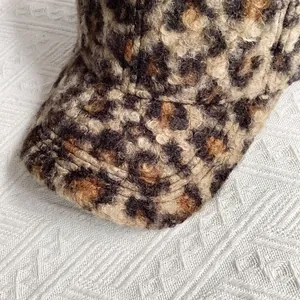 Detailopname van de luipaardprint imitatiebont textuur en stiksels van de baseballpet