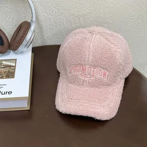 Detail of pink plush baseball cap showing embroidery and soft faux fur texture