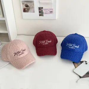 Detailed view of lamb wool baseball caps in pink, burgundy, and blue with embroidery