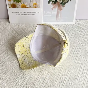 Detail of yellow and white checkered sequined baseball cap with adjustable metal buckle