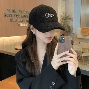 Detail of white Balance embroidery on thick black faux shearling winter baseball cap