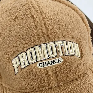Detailed view of the PROMOTION embroidery and soft brown sherpa fleece fabric on cap