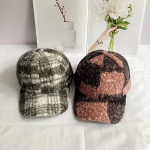 Detailed macro view of two plaid teddy velvet baseball caps in gray and orange tones