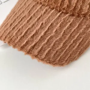 Macro detail of brown plush baseball cap with striped faux fur texture and soft finish
