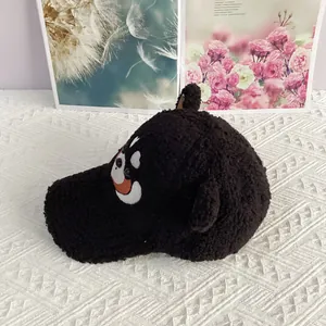 Détail de la casquette en polaire noire avec oreilles et broderie de dessin animé