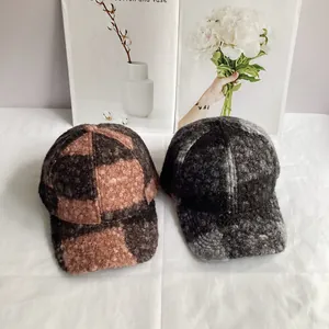 Two thick teddy fleece baseball hats in brown plaid and grey blend on a white fabric