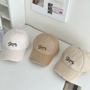 Detailed view of three fuzzy Balance embroidered baseball caps in neutral autumn colors