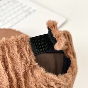 Detailed view of brown plush baseball cap with adjustable black velcro strap on the back