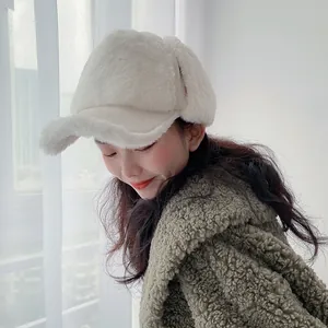 Close-up of white plush earflap baseball cap featuring soft faux fur texture and brim